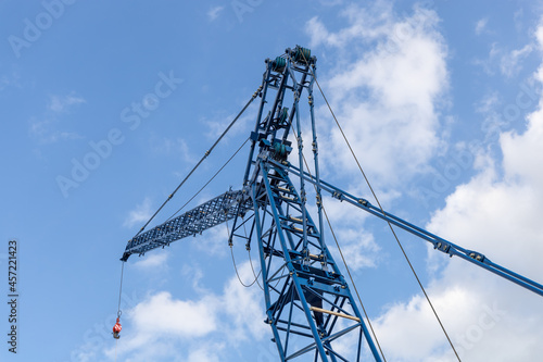 Lattice jib of a crawler crane against the blue sky, low viewing angle. Heavy equipment for construction, installation and repair work photo