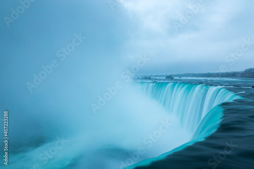 A stormy morning over the iconic Niagara Falls located on the boarder of the United States and Canada. photo