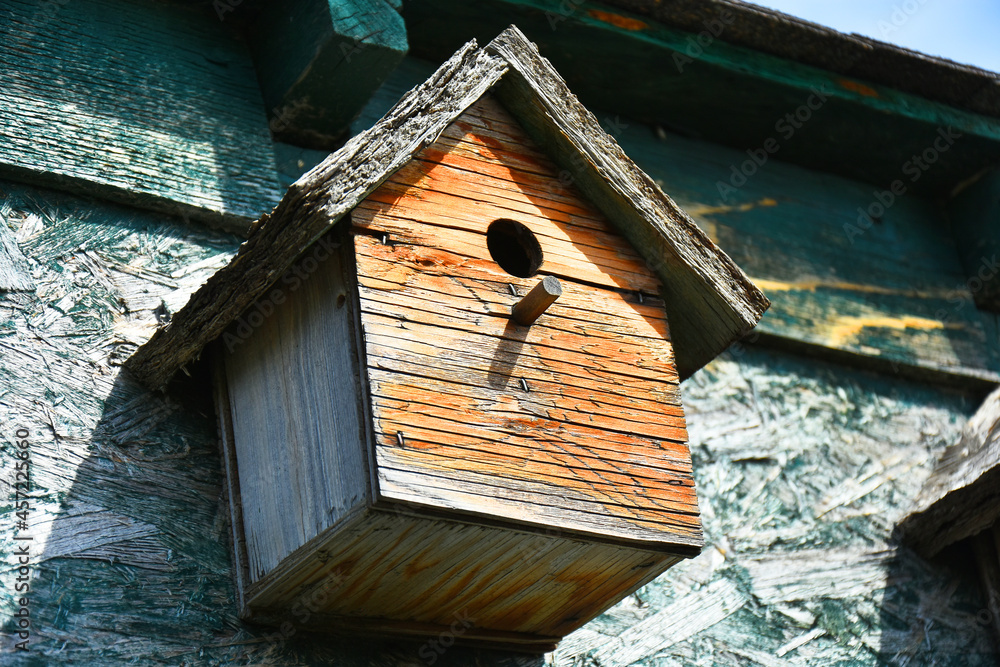 An image of old wooden hand made bird houses on a wooden granary. 