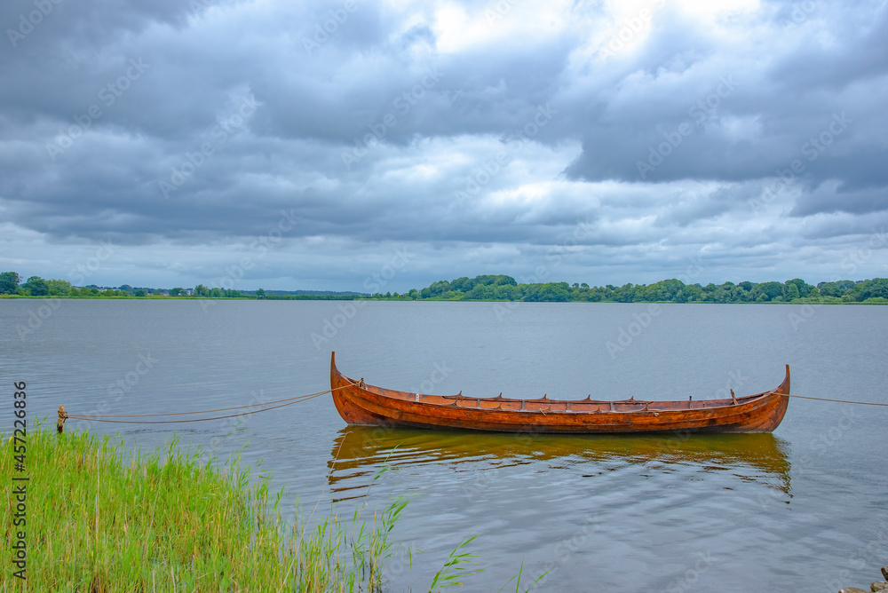 View of small viking boat karve by the river shore