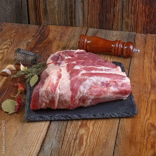 Raw pork ribs are laid out on a cutting board.Spices for cooking meat dishes close-up.Selective Focus.