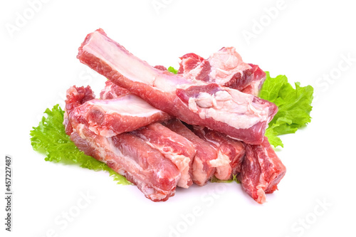 Sliced pork ribs on a lettuce leaf are isolated on a white background.Preparation of meat dishes.