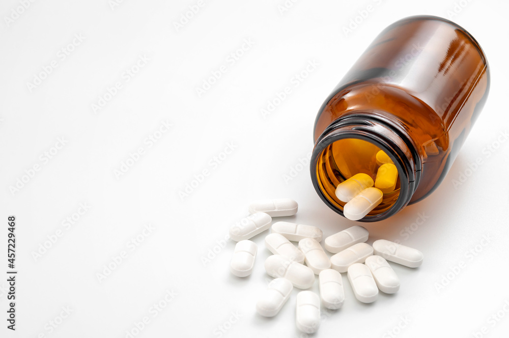 Addictive pain relief drug, oral administration therapeutic medicine and healing science concept with many spilling red prescription medication isolated on white background with copy-space Addictive pain relief drug, oral administration therapeutic medicine and healing science concept with many spilling red prescription medication isolated on white background with copy-space