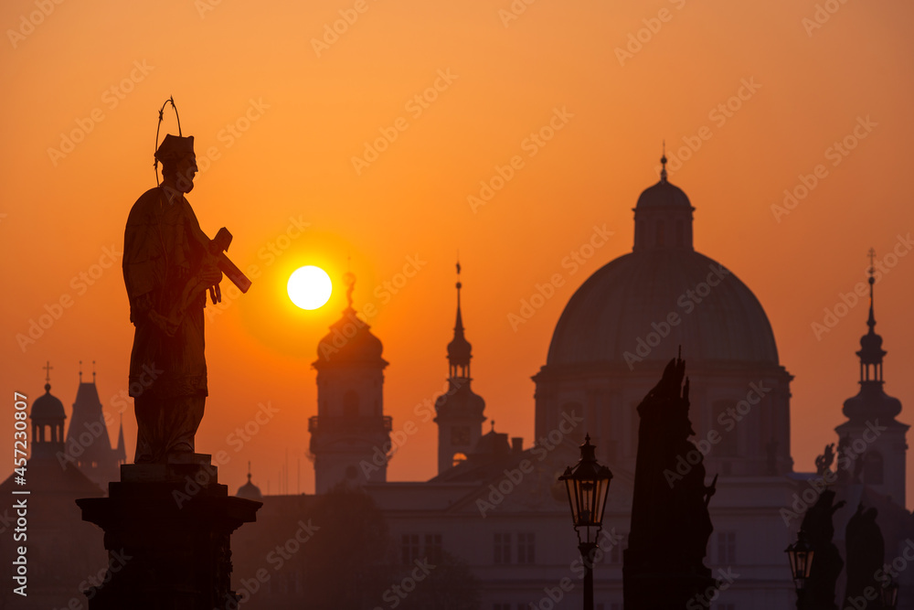 Sunrise over the capital of the Czech Republic - Prague city with silhouettes of buildings and statues