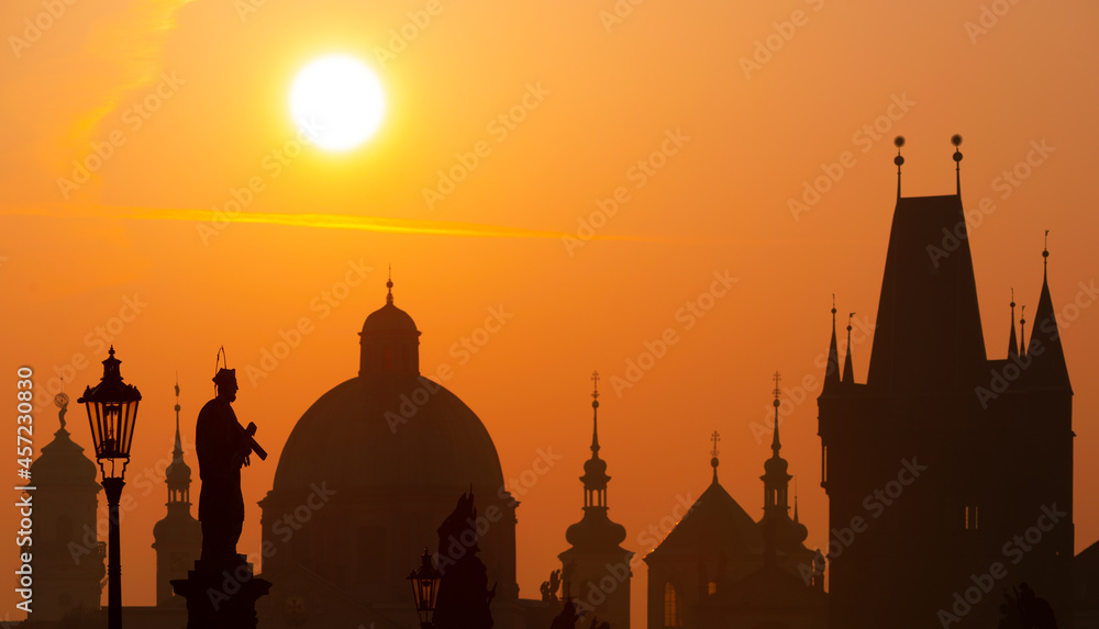 Sunrise over the capital of the Czech Republic - Prague city with silhouettes of buildings and statues