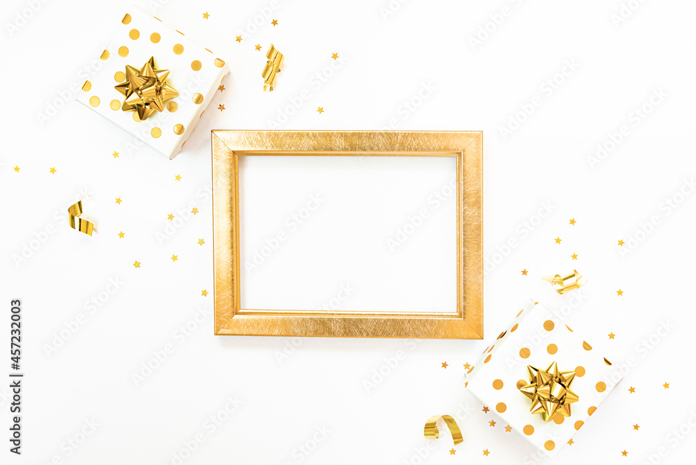 Top view of golden dotted gift boxes and golden empty frame on a white background. Copy space, mock-up