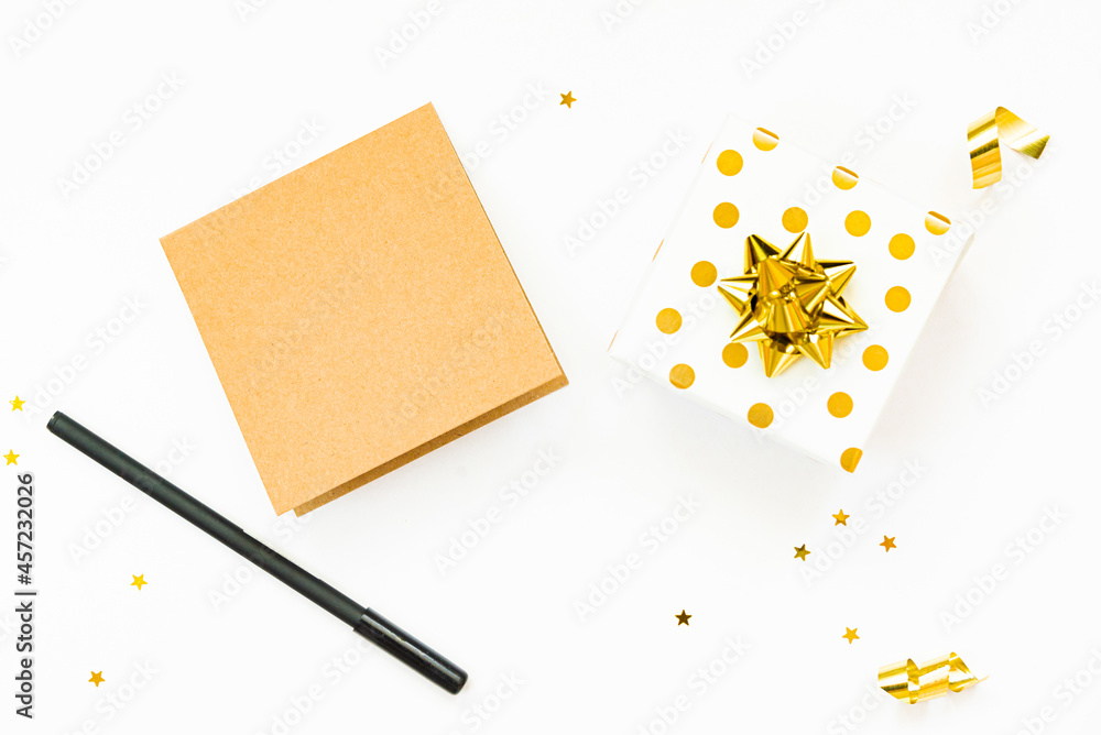Top view of golden dotted gift boxes and an empty card on a white background. Copy space, mock-up.