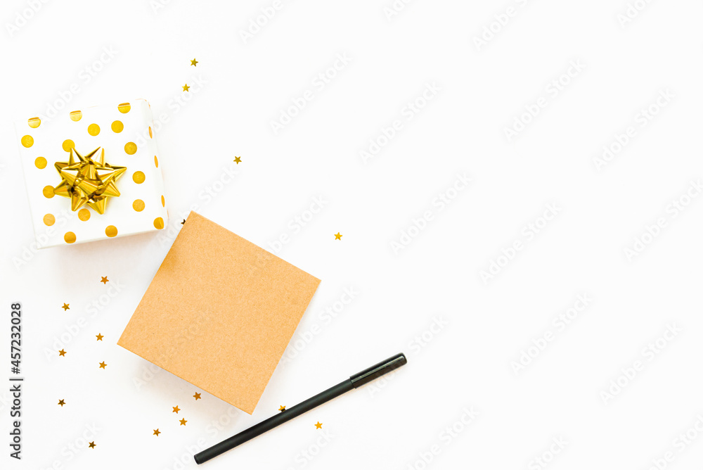 Top view of golden dotted gift boxes and an empty card on a white background. Copy space, mock-up.