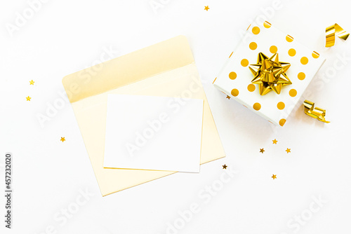 Obraz na płótnie Top view of golden dotted gift box and an open envelope with empty card on a white background. Copy space, mock-up. w salonie