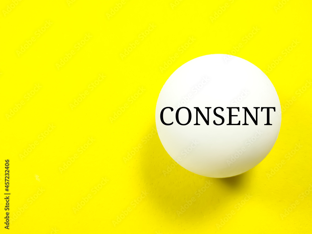 Medical concept.Text CONSENT writing on ping pong ball on a yellow background. Medical concept.Text CONSENT writing on ping pong ball on a yellow background.