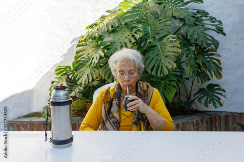 Latin American woman, elderly, drinking mate in the courtyard of her house. Argentine, Uruguayan, Brazilian, Paraguayan, Chilean infusion.