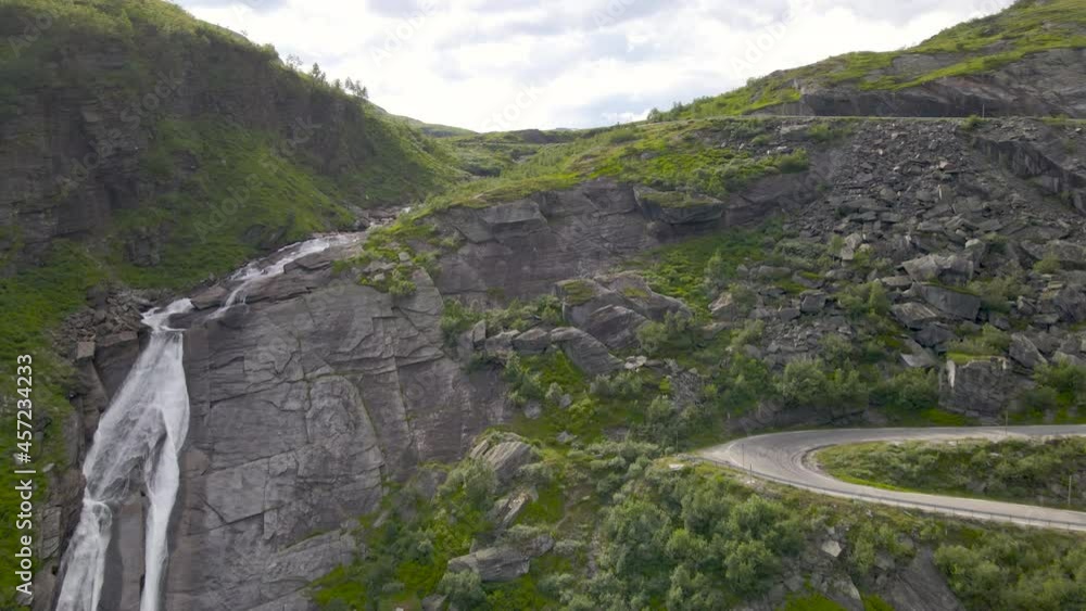 Drone shot rising over a waterfall to reveal a mountain valley landscape, Norway Drone shot rising over a waterfall to reveal a mountain valley landscape, Norway