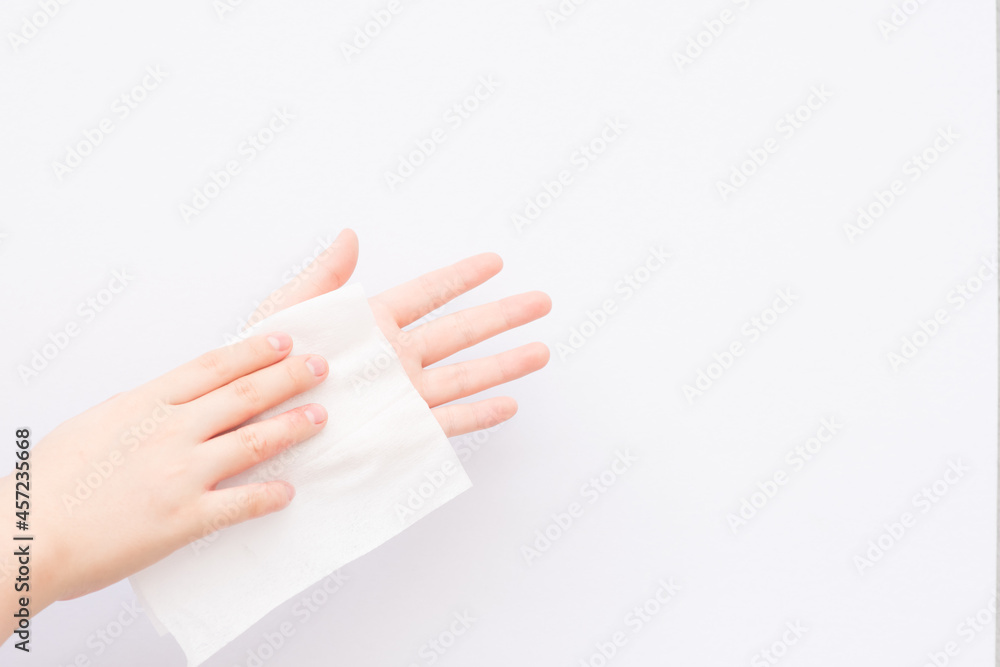 Young girl cleans her hand by rubbing it in a wet tissue Young girl cleans her hand by rubbing it in a wet tissue