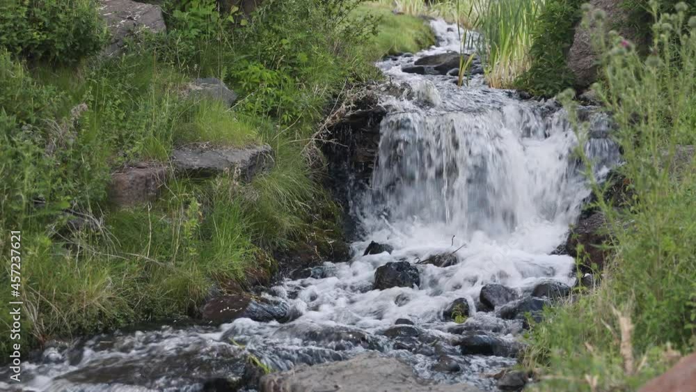 Clear fresh water on small waterfall on stream in mountain valley meadow Clear fresh water on small waterfall on stream in mountain valley meadow