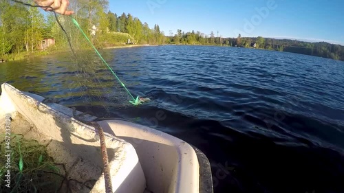 Pulling in a fishing net in a small lake in Norway. The catch is a European Perch. Early spring. Sportsfishing, fishing for food. photo