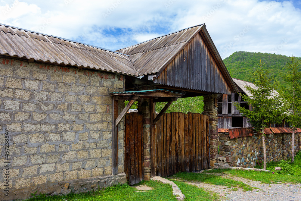 A chalet, a mountain village, an old style of architecture a variety of buildings and court buildings and fences.