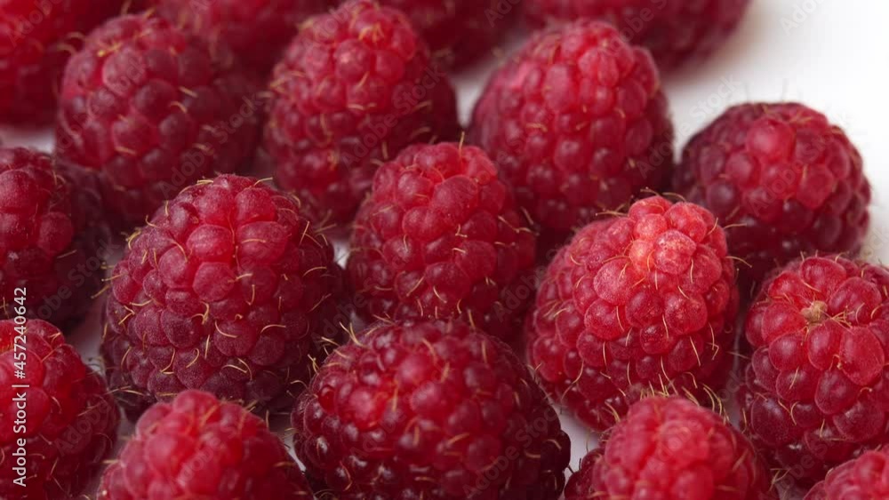 Raspberries spinning on a plate on white background for a restaurant, juicy raspberries for advertising, fresh raspberries close-up Raspberries spinning on a plate on white background for a restaurant, juicy raspberries for advertising, fresh raspberries close-up