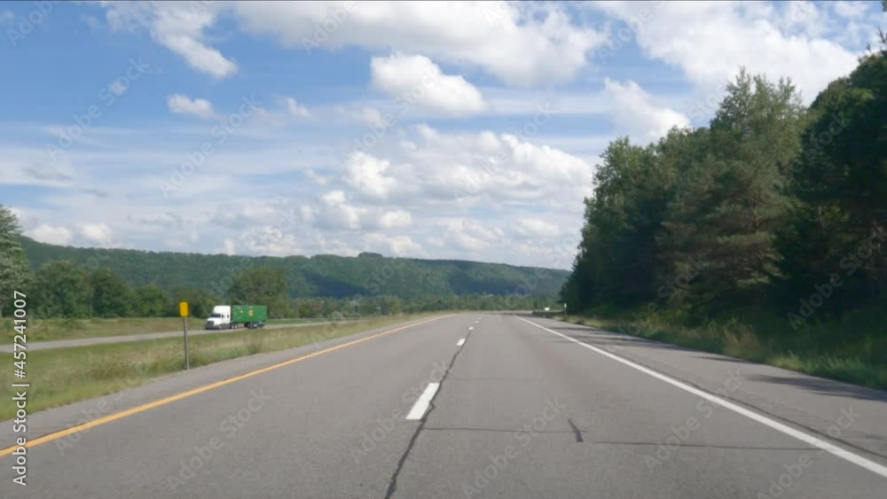 A view of the highway while driving during the daytime in the summer. A view of the highway while driving during the daytime in the summer.