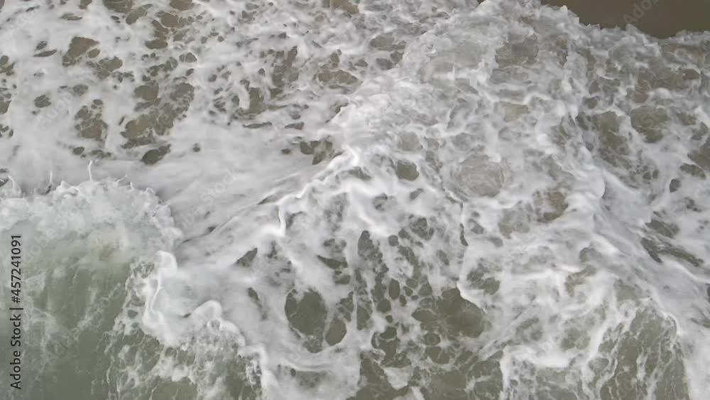 Slow motion powerfull waves crashing against rocks in the ocean on stormy day Slow motion powerfull waves crashing against rocks in the ocean on stormy day