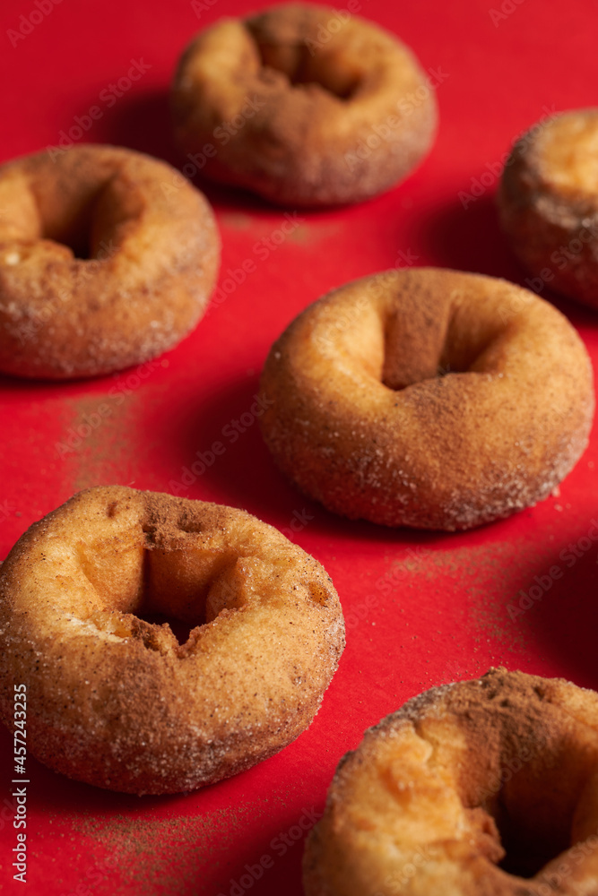 A pattern of freshly baked cinnamon donuts A pattern of freshly baked cinnamon donuts