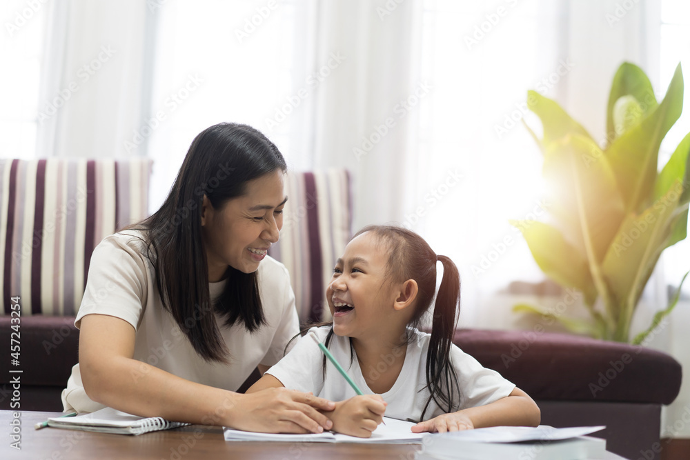Happy asian little girl with mother teaching homework, Study From Home idea concept Happy asian little girl with mother teaching homework, Study From Home idea concept