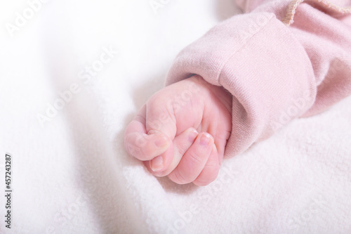 Newborn girl caucasian hand in fist.