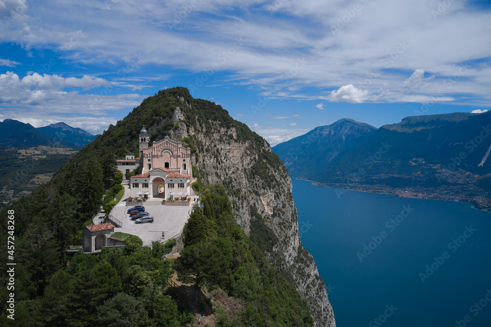 Historic catholic church on the mountain, background of the Alps. Panorama Eremo di Montecastello, Italy aerial view. Aerial panorama of the historic church Eremo di Montecastello on Lake Garda.