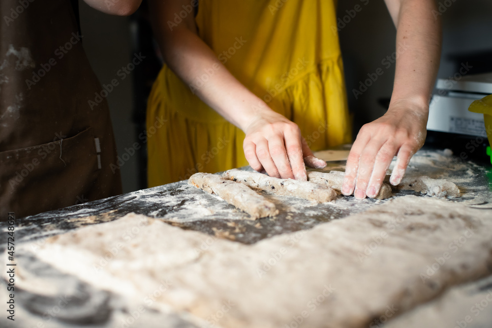 Molding rye sticks with chocolate and hazelnuts by a woman