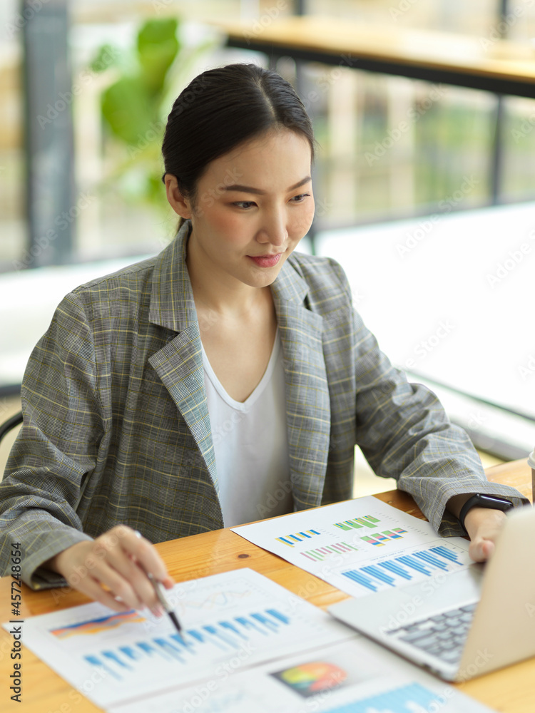 Asian woman working on laptop. Businesswoman busy working on her financial project Asian woman working on laptop. Businesswoman busy working on her financial project