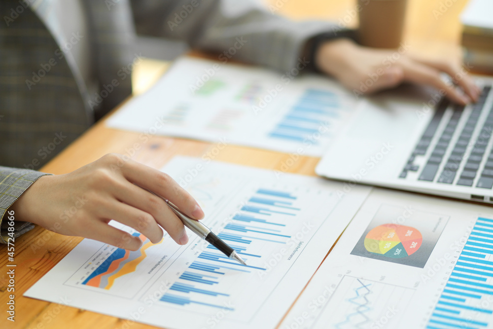 Closeup image of beautiful businesswomen working in office with financial data reports chart Closeup image of beautiful businesswomen working in office with financial data reports chart
