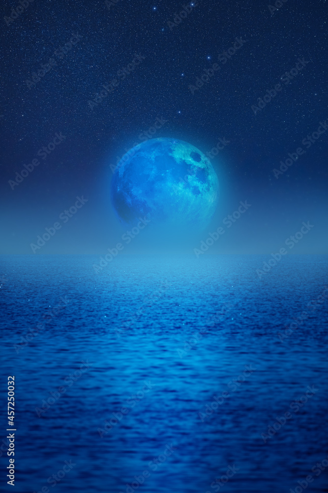 Full Moon rising above ocean horizon.