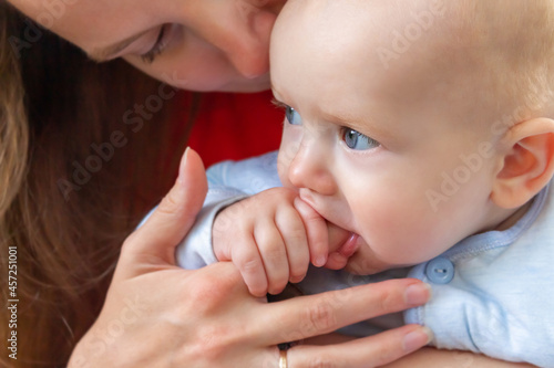 Little baby holding mother's finger in mouth.