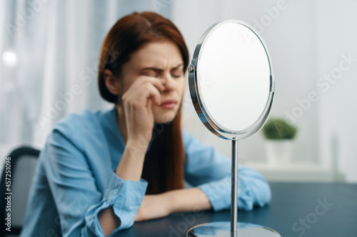 Fototapeta Naklejka Na Ścianę i Meble -  woman in front of the mirror cosmetics dermatology makeup skin care