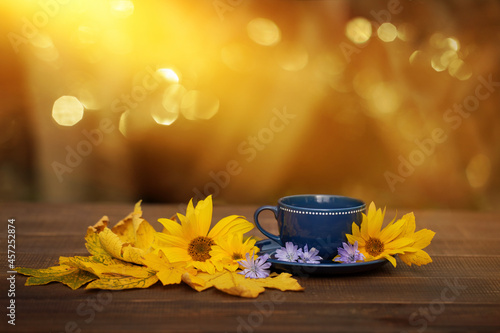filiżanka kawy w jesienny poranek, kawa o poranku, żółte kwiaty słonecznika photo