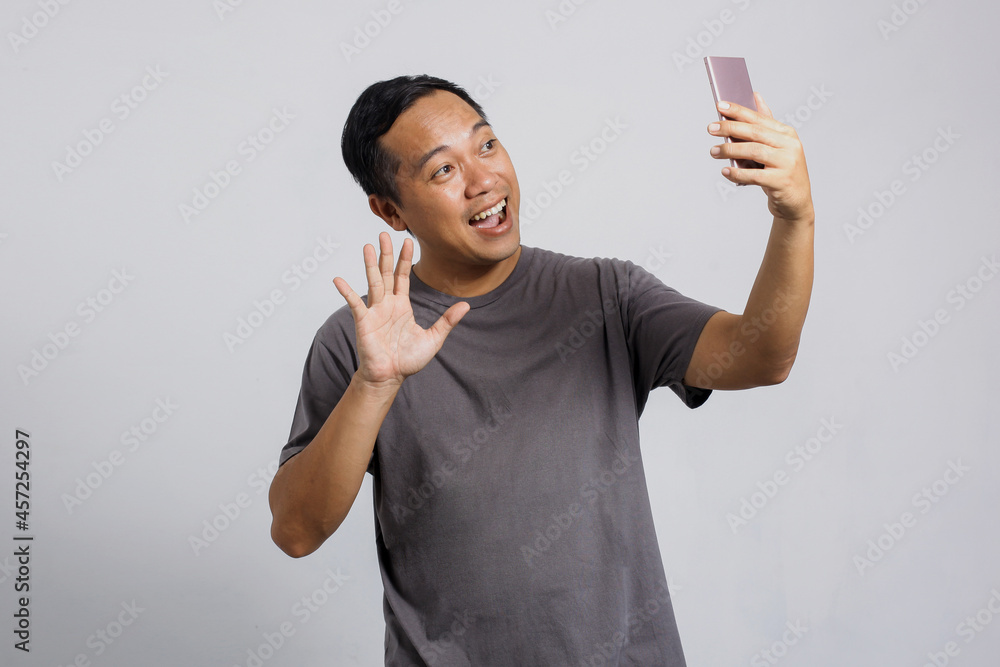 Asian man having video call with someone through smart phone Asian man having video call with someone through smart phone