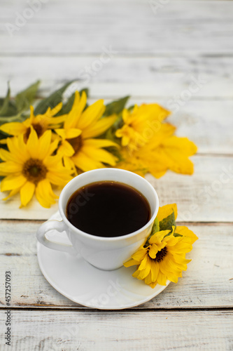 a cup of coffee in the autumn morning, coffee in the morning and yellow sunflower flowers on white boards