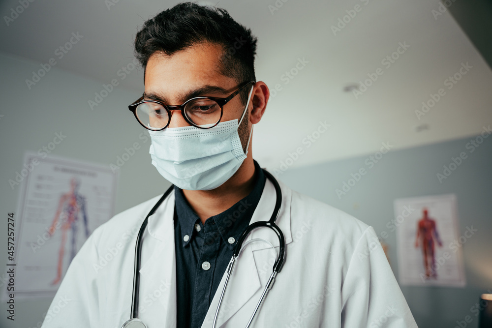 Mixed race male doctor wearing glasses working n clinic Mixed race male doctor wearing glasses working n clinic