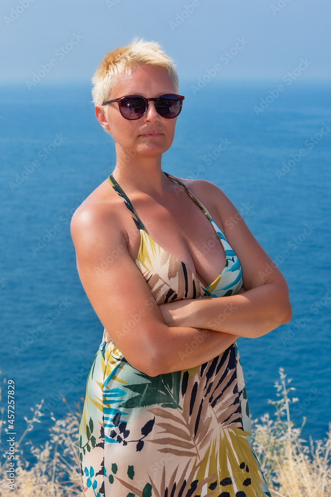a woman with short blonde hair and sunglasses at sea