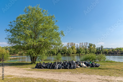 Novi Sad, Serbia - April 25, 2021: Sodros lake beach on Danube in Novi Sad, Serbia. People collect garbage and clean the shore photo