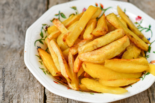  Home made   Fresh fried French fries  in a bowl on wooden rustic  background