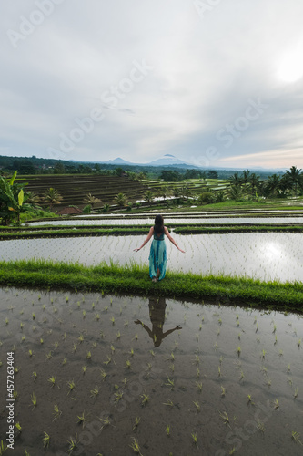 Girl in a hat walks in a rice field, Bali, Indonesia.