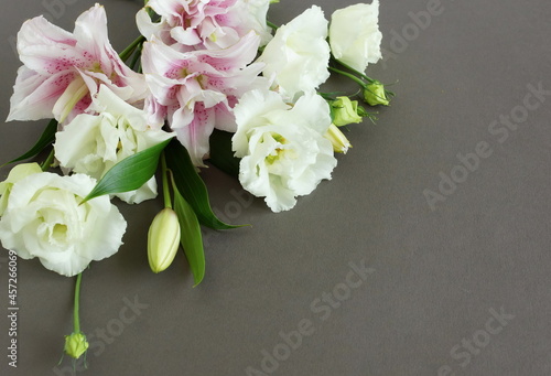 White and pink flowers bouquet on brown background top view, copy space. Flowers composition template.Floral card.