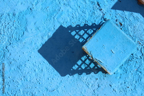 A blue wall with a shadow on it.