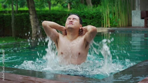 slow-motion of young man splashing water with his head photo