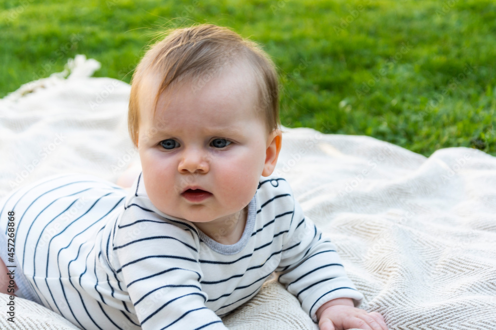 Baby child infant laying down on a blanket. Baby activity health care, education and parenting concept. Baby child infant laying down on a blanket. Baby activity health care, education and parenting concept.