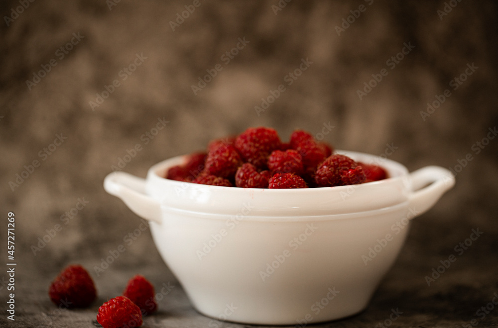 raspberries in a bowl on a wooden table raspberries in a bowl on a wooden table