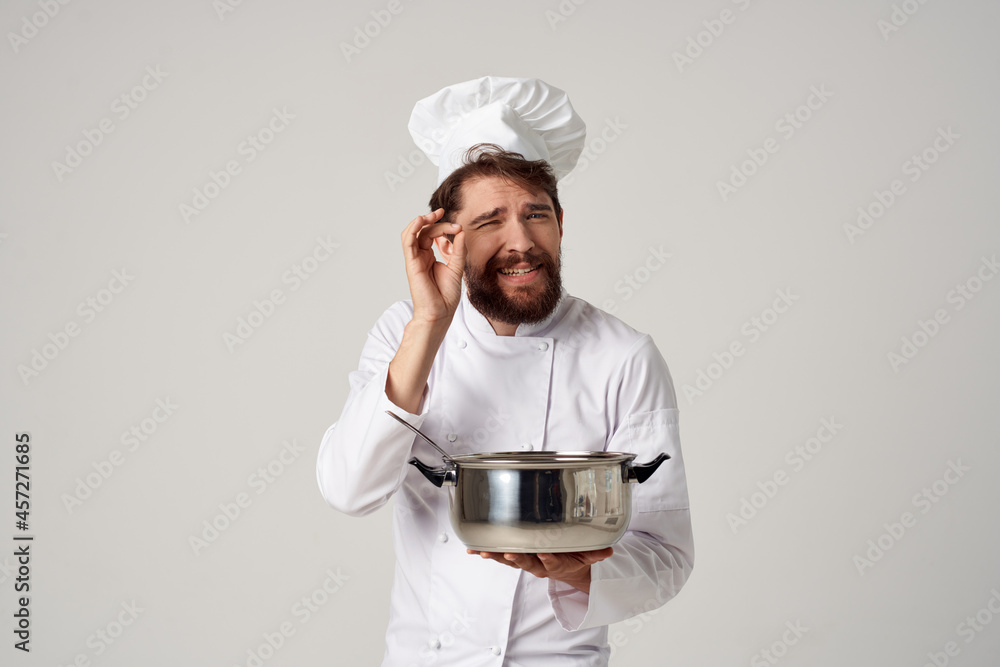 professional male chef in a restaurant with a saucepan in the hands of providing service professional male chef in a restaurant with a saucepan in the hands of providing service