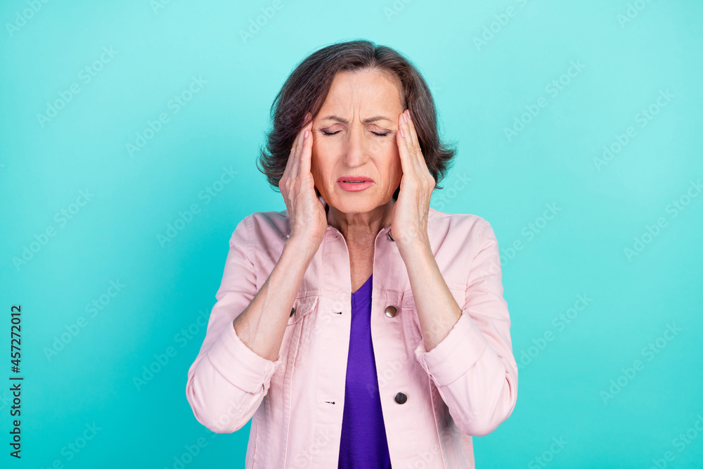 Photo portrait woman in casual clothes suffering from head ache need pills isolated vibrant teal color background Photo portrait woman in casual clothes suffering from head ache need pills isolated vibrant teal color background