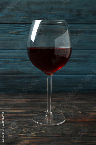 Glass of red wine on rustic wooden background