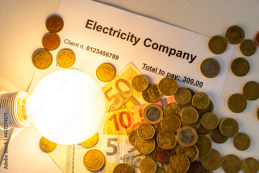 Light bulb on, with banknotes, coins and energy bill. Increase in
